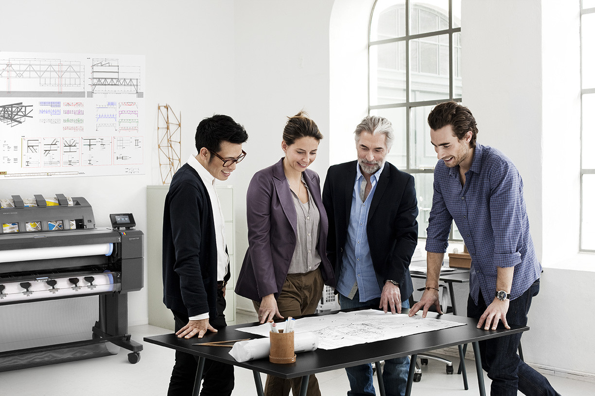 Equipo de arquitectos revisando un plotter