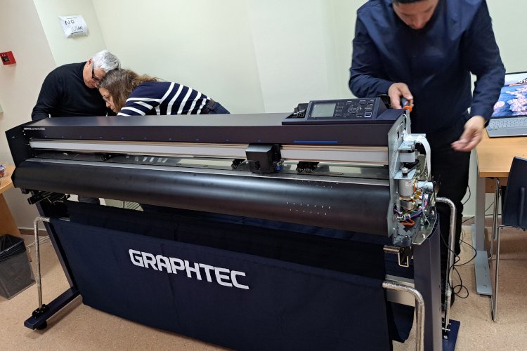 Tecnicos verificando un plotter de impresión